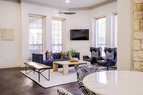 A living room with a blue couch and a television on the wall.